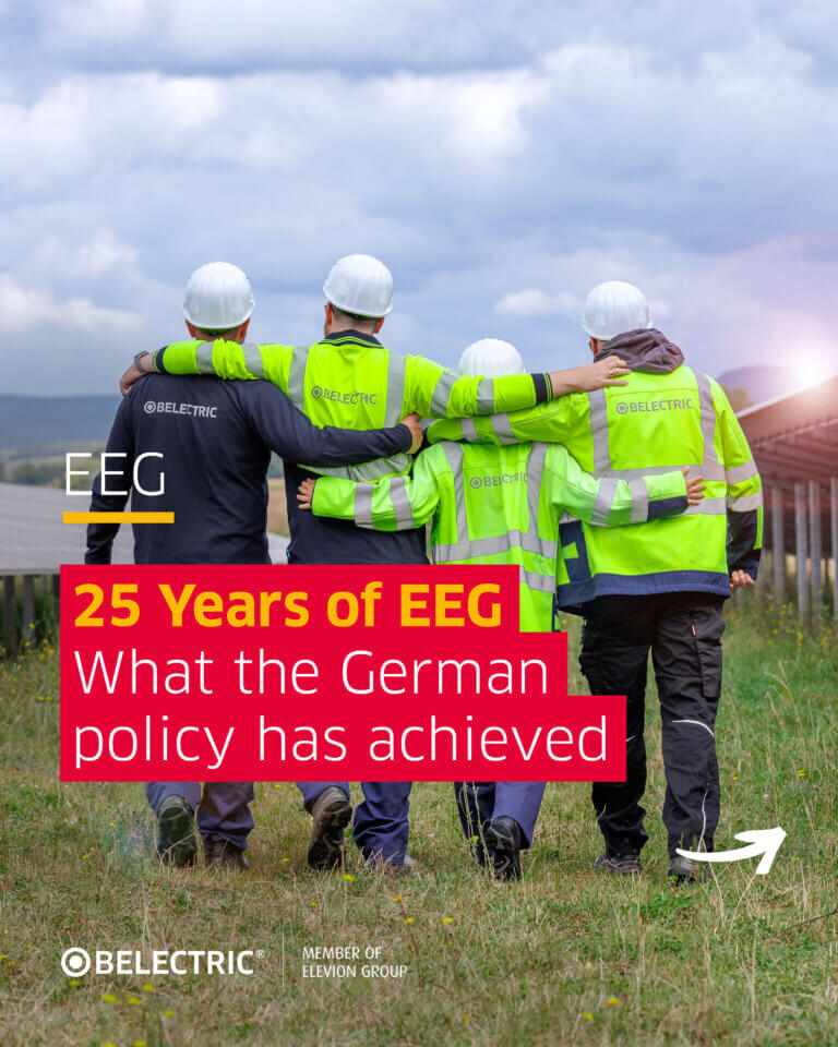Rear view of four employees in safety clothing hugging each other and running towards solar panels with the headline: 25 Year of EEG What the German policy has achieved.