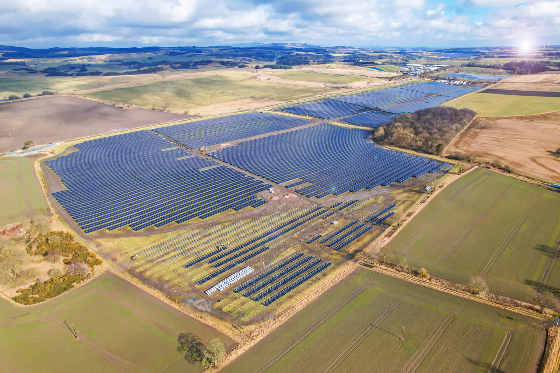 A BELECTRIC solar farm shown from above. In the distance, you can see hills and the sun setting.