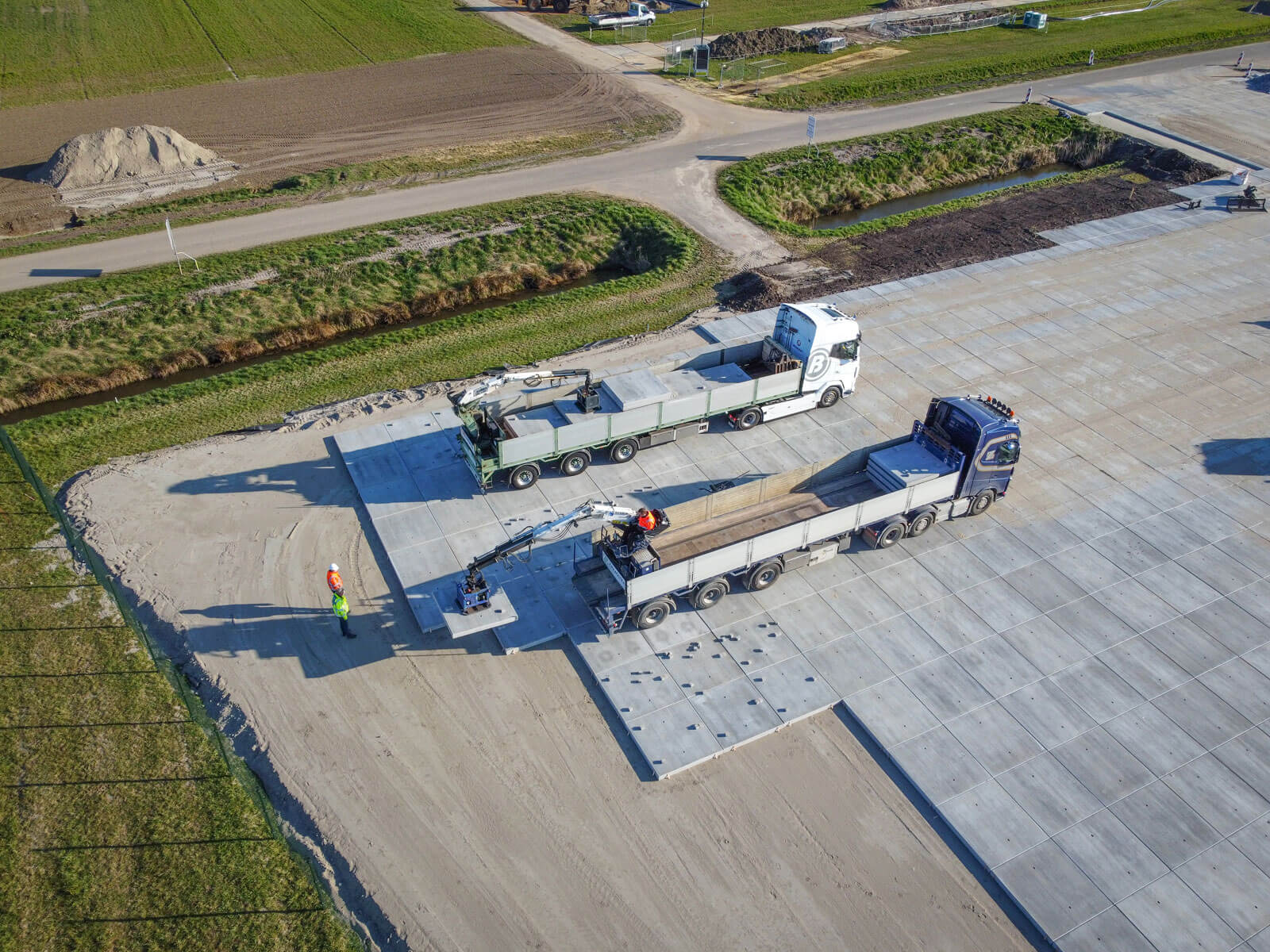 building of a storage area at a construction site of a solar farm with two trucks in front