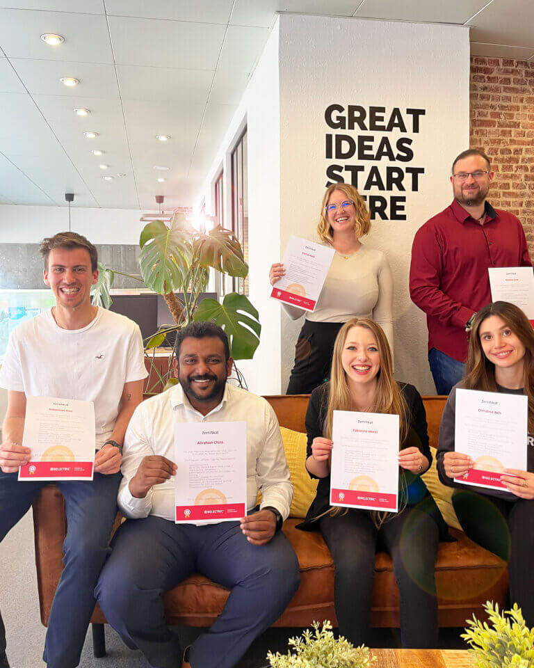 Six smiling employees holding certificates