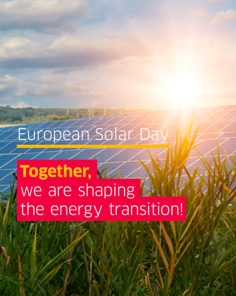 Several solar modules on a field with the slogan together we are shaping the energy transition