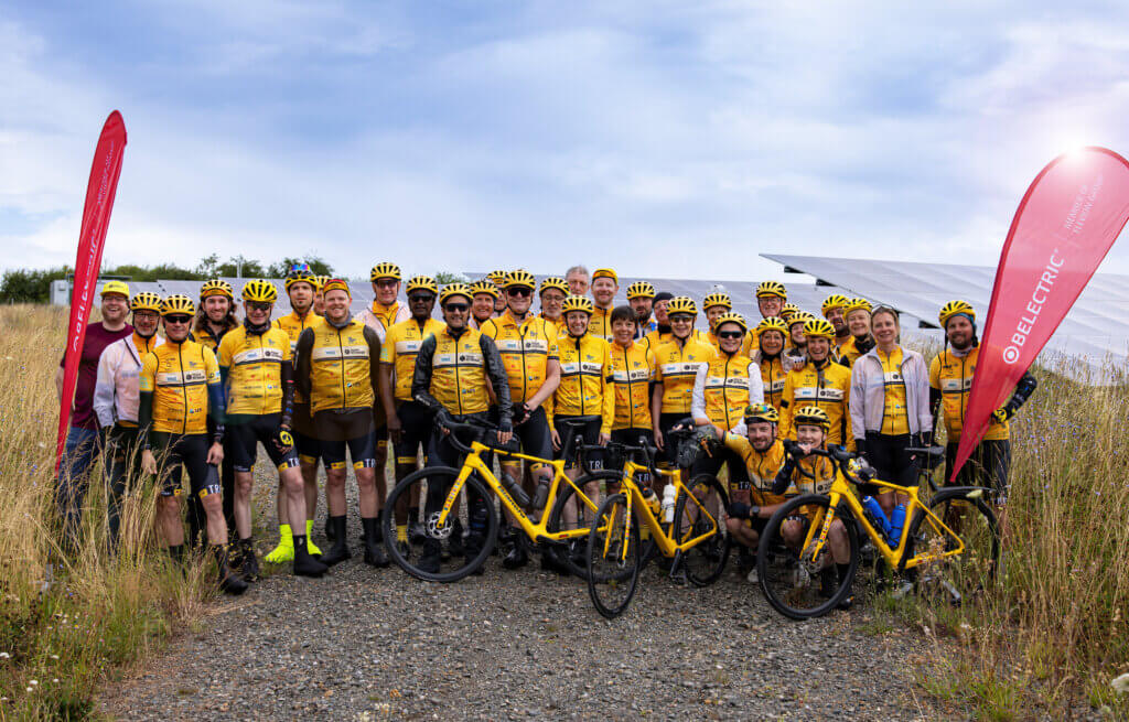 The cycling Team Rynkeby Berlin stands in front of BELECTRIC's solar farm in Reddehausen.