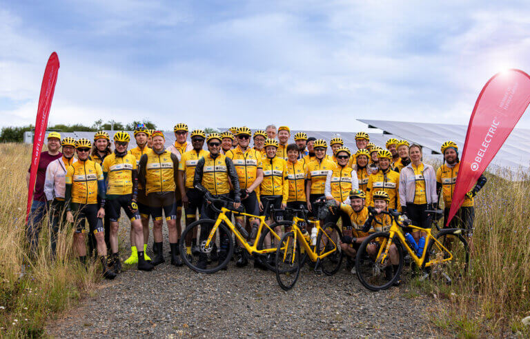 The cycling Team Rynkeby Berlin stands in front of BELECTRIC's solar farm in Reddehausen.