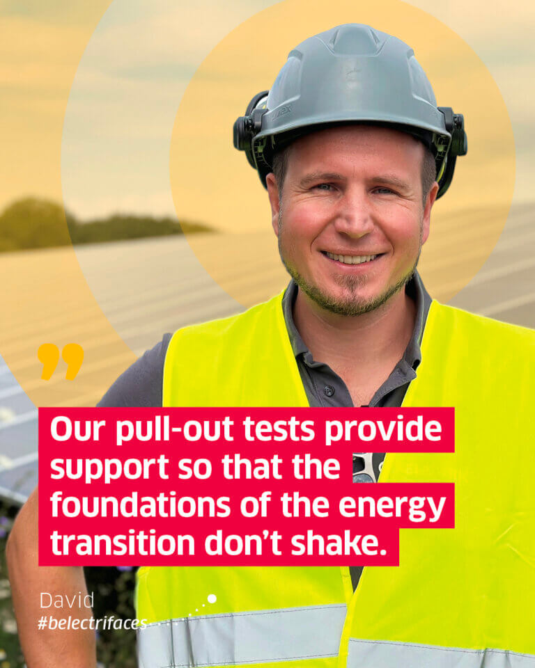 Smiling employee in front of a solar panel with a quote